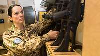 Eine Soldatin hebt ein Gewehr G36 aus der Gewehrhalterung