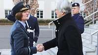 Zwei weibliche Personen, eine davon in britischer Uniform, geben sich die Hand