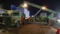 Ein amerikanischer LKW wird mit einem Container beladen.
