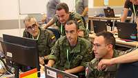 Spanische Sldaten sitzen an Comuptern