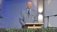 Ein Soldat im Dienstanzug steht hinter einem Rednerpult und spricht.