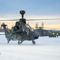 Zwei Hubschrauber stehen auf dem verschneiten Hubschrauberlandeplatz.