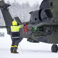 Ein Soldat hält vor dem Hubschrauber die gezogenen Sicherheitssplinte in die Höhe.