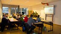 Interessierte Bewerber sitzen im Vortragsraum und hören gespannt zu