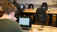 Bewerber sitzen hochkonzentriert an den Laptops und machen den Test