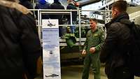 Ein Hubschrauberpilot steht vor dem Sea Lynx und spricht über technische Daten