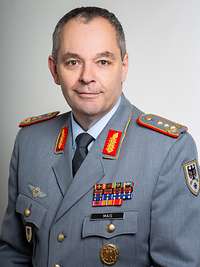 Ein Soldat im Dienstanzug schaut freundlich in die Kamera.