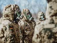 Die Soldaten bei der Einweisung in das weitere Vorgehen. Mehrere Soldaten in ABC-Schutzkleidung stehen zusammen