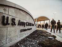 Soldaten laufen an einer Mauer mit dem Schriftzug „U.S. Army CBRN School“ vorbei