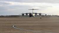 Ein Transportflugzeug der Bundeswehr wird auf dem Rollfeld eines Flughafens eingewiesen