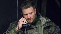 Ein deutscher Soldat spricht in ein Funkgerät.
