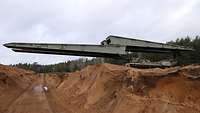Ein Brückenpanzer fährt seine Brücke aus