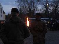 Zwei Kameraden des Objektschutzregimentes der Luftwaffe tragen Fackeln und stehen auf dem Rathausplatz in Diepholz.