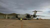 Ein Transportflugzeug der Bundeswehr wird auf dem Rollfeld eines Flughafens eingewiesen