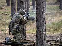 Ein Soldat schießt mit seiner Waffe im Wald.