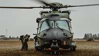 Zwei Soldaten nähern sich einem Hubschrauber.