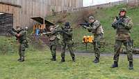 Fünf Soldaten zielen mit Gewehren