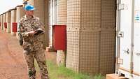 Ein Soldat steht neben einem Container