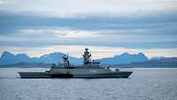 Ein graues Boot fährt durch norwegisches Gewässer.