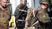 Ein Soldat hat die Granatmaschinenwaffe auf dem Rücken. 
