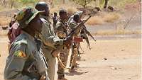 Eine Gruppe malischer Soldaten mit Waffe steht in einer Reihe