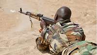 Ein malischer Soldat liegt am Boden und schießt