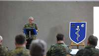 Generalstabsarzt Dr. Schoeps steht am Redepult und spricht zu den Teilnehmenden.
