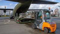 Ein Militärflugzeug wird mit einem Gabelstapler beladen