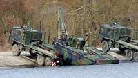 Ein Brückentransporter steht am Ufer und zieht ein Motorboot 3 aus dem Wasser