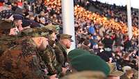 Die Soldaten sind in ihren Uniformen auf der Tribüne des Berliner Olympiastadions.