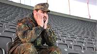 Soldat allein auf der Tribüne des Stadions.