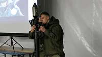 Zwei Soldaten fügen das Griffstück an die Patrone einer Panzerfaust