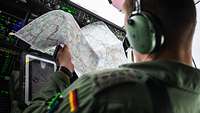 Pilot prüft die Route auf der Karte Der A400M-Pilot prüft während des Fluges die Route auf seiner Karte von Norwegen