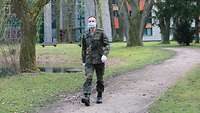 Spaziergang mit Mundschutz Oberstleutnant Miloje Zdravkovic geht in der Kaserne spazieren (Übersetzung englisch und französisch)