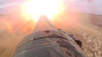 Ein großer Feuerball vor dem Rohr eines Kampfpanzers beim scharfen Schuss