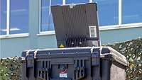 Auf dem Transportkoffer stehende Antenne der Satellitenkommunikationsanlage BGAN 710
