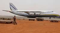 Anja H. steht vor einem Frachtflugzeug des Typs Antonov 124, das regelmäßig Material nach Mali liefert