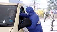 Frau im Auto gibt eine Speichelprobe ab