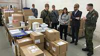 Die Besucher stehen im Bereich des Versands. Dort werden Pakete gepackt und für den Versand aufbereitet.