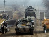 Zwei Panzer vom Typ Fuchs und Marder fahren eine unbefestigte Straße entlang