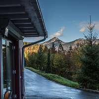 Building with forest and mountain range in the background