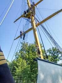 Im Vordergrund ist der Ärmel mit dem Dienstgrad eines Korvettenkapitäns zu sehen und dahinter der Gorch-Fock-Übungsmast