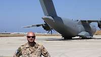 Ein Soldat steht vor einem Transportflugzeug Airbus A400M