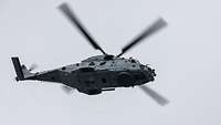 A military helicopter in flight, seen from below