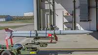 Rakete vom Typ Meteor auf einem Beladegestell im Hangar