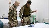 Zwei deutsche Soldaten schauen sich medizinische Geräte an