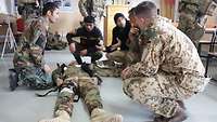 Ein deutscher Soldat bespricht die Erste-Hilfe-Ausbildung mit afghanischen Soldaten