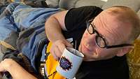Der Redakteuer auf seinem Sofa mit einer Tasse Kaffee