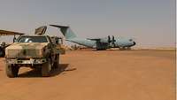 Ein Dingo 2 steht am Flughafen Gao, dahinter ist ein französischer Airbus A400M zu sehen