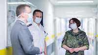 Drei Soldaten in verschieden Uniformen und Atemschutz unterhalten sich